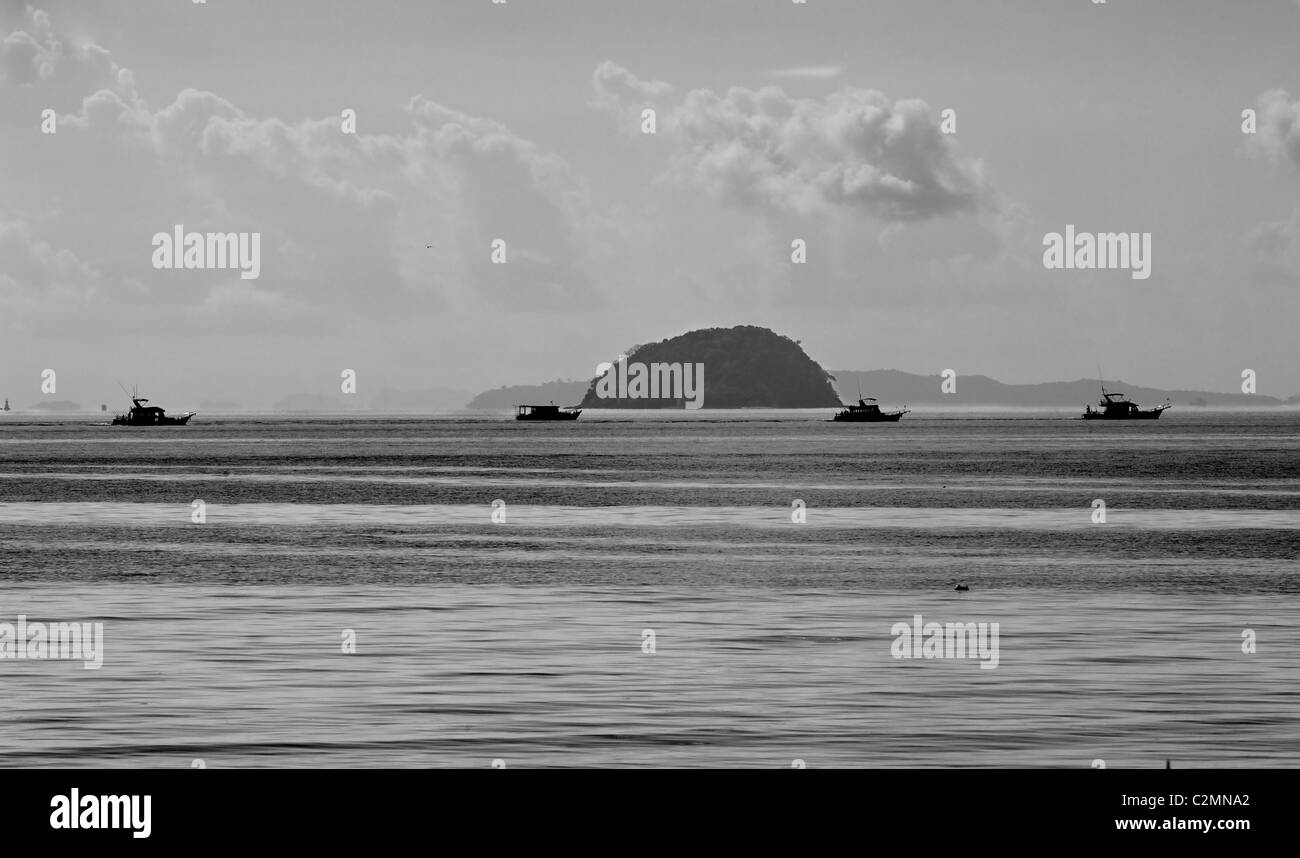 Tourist fishing boats heading for game fishing areas around the island of Phuket, Thailand Stock Photo