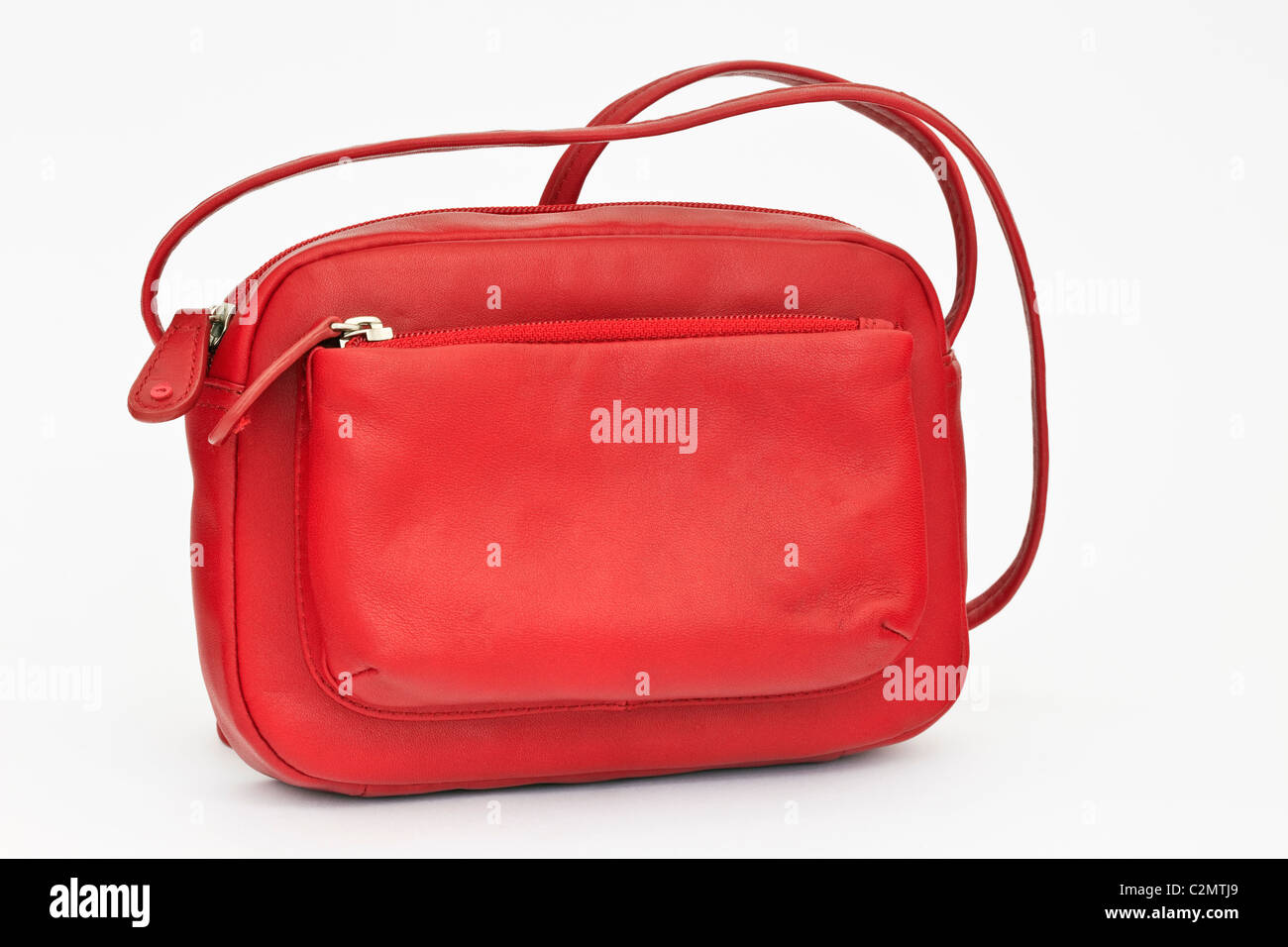 Red leather handbag with zipped compartment and shoulder strap on a plain white background Stock Photo