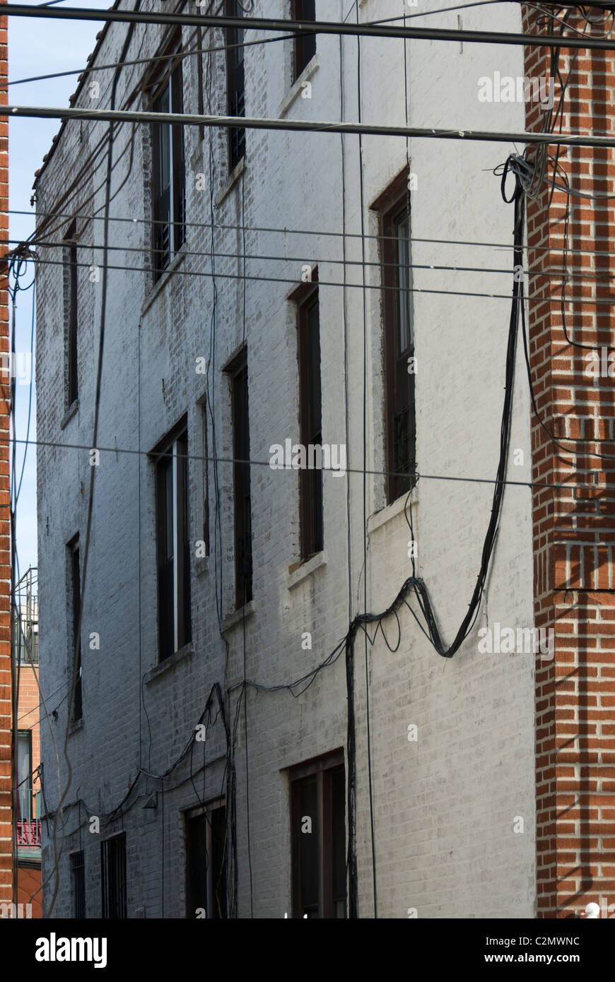 Bundles of electrical cables hanging on a facade. Long Island, Queens