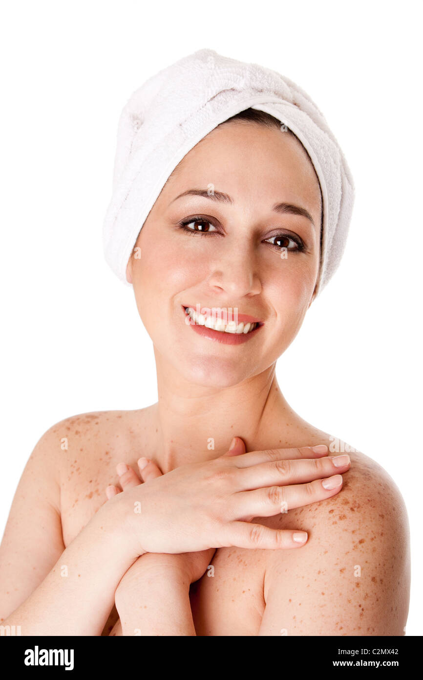 Healthy radiant woman female face with towel around head finished bath shower spa treatment touching her shoulder skin. Stock Photo