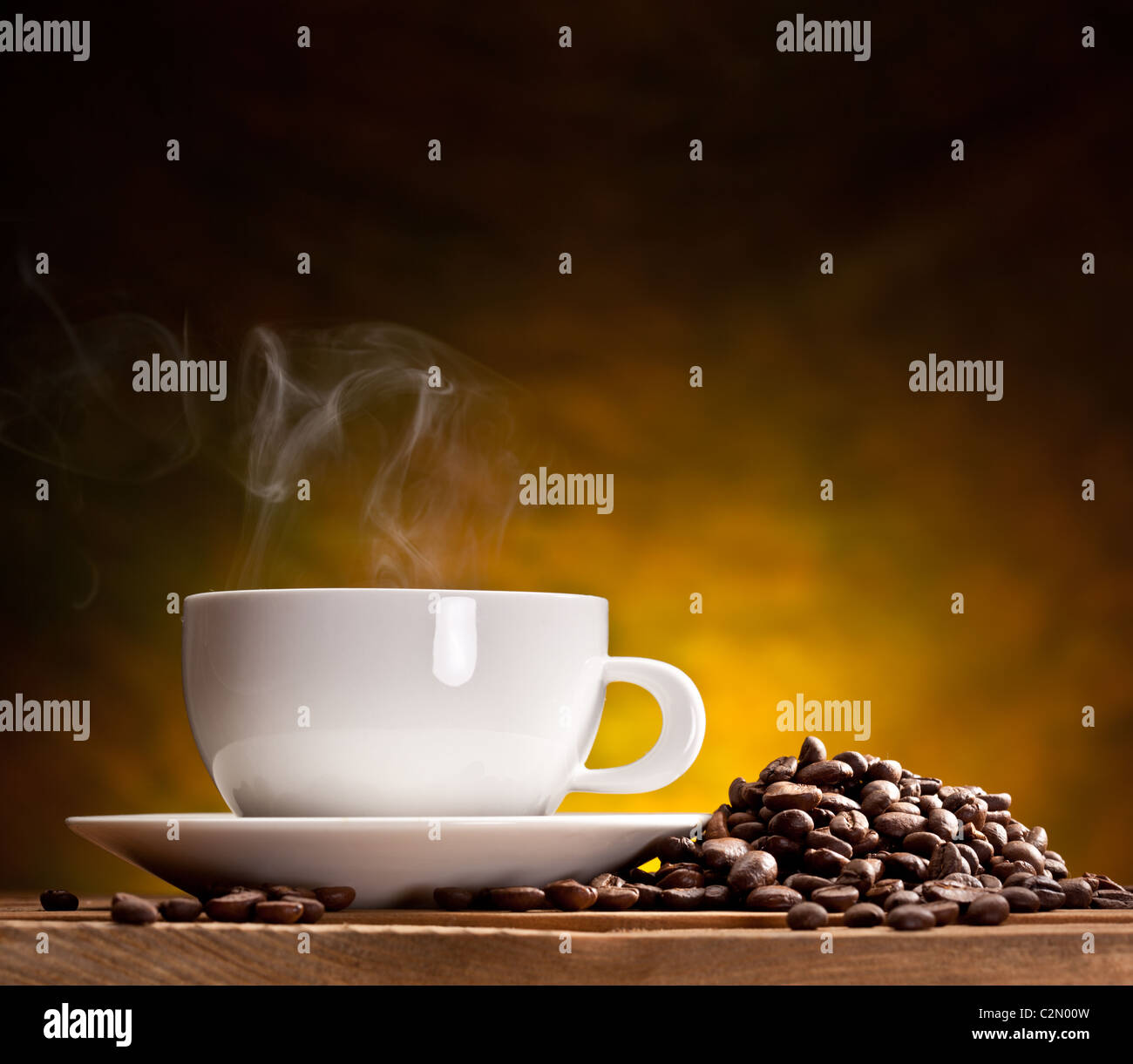 Cup of coffee with coffee beans on a beautiful brown background. Stock Photo