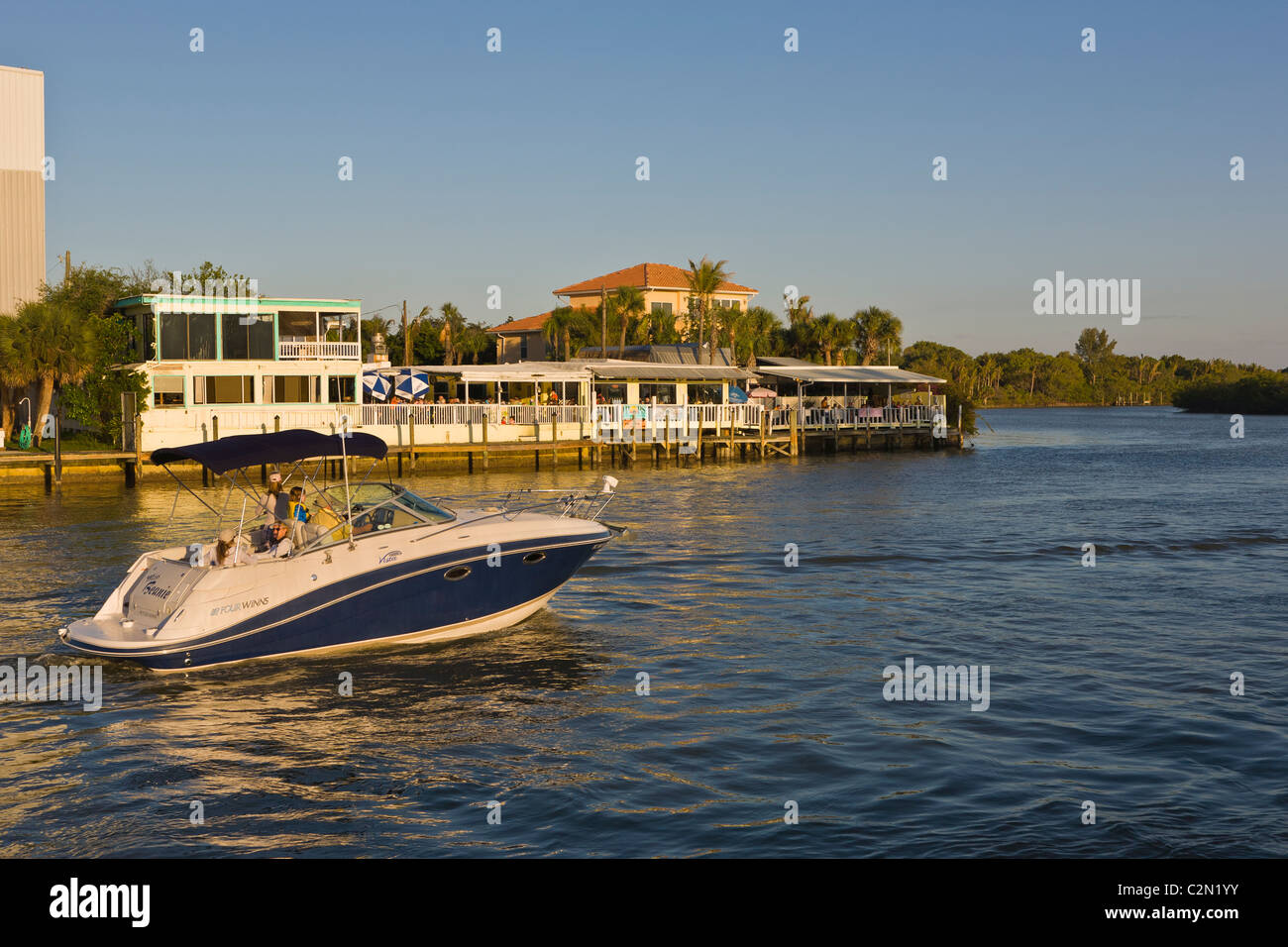 Boat going by Pops Sunset Grill outdoor restaurant on the Gulf