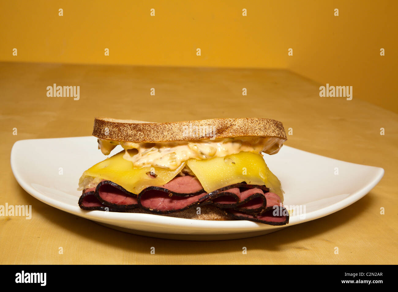 A Reuben sandwich with corned beef sauerkraut swiss cheese and thousand