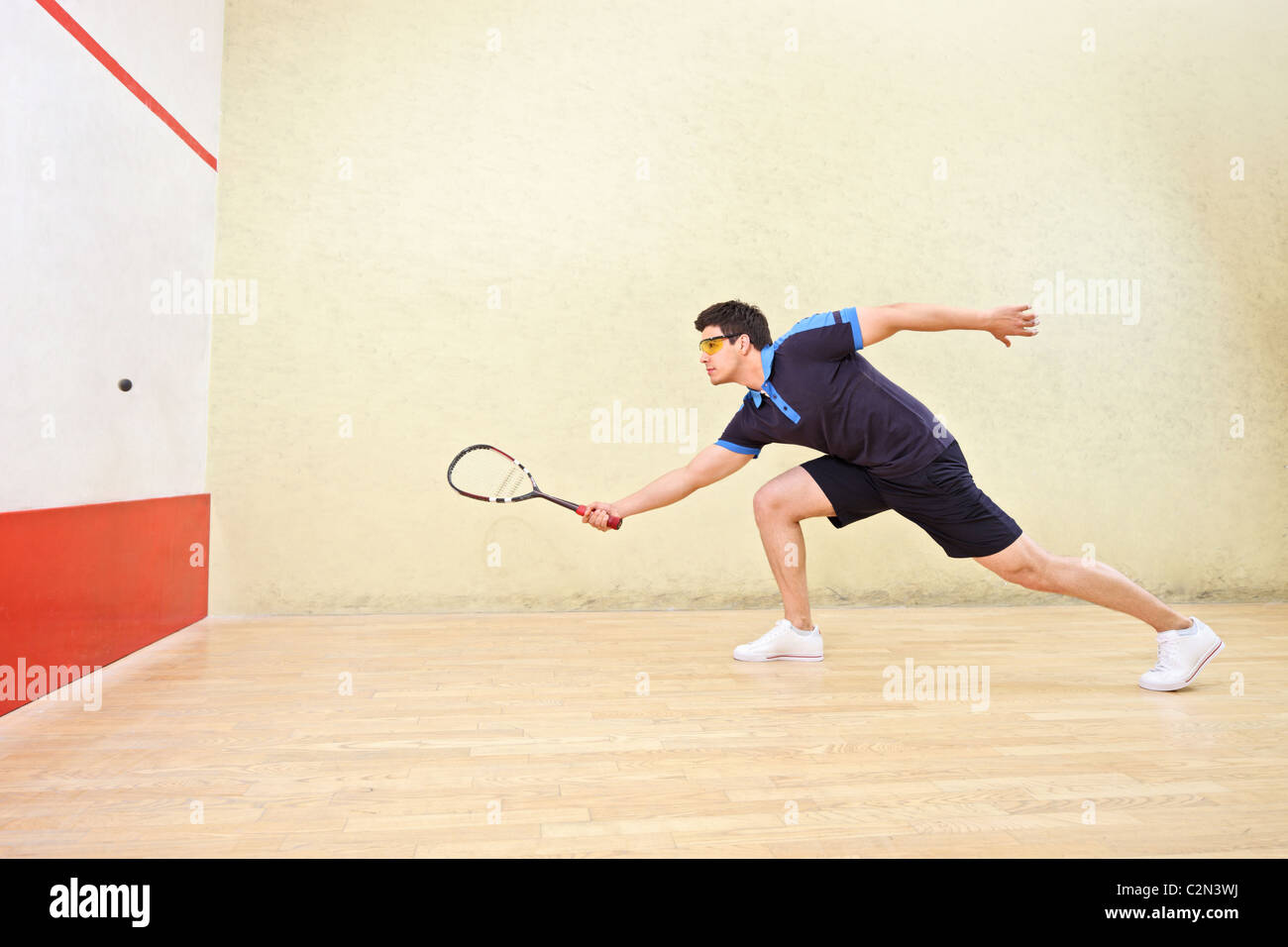 Squash player hitting a ball in a squash court Stock Photo Alamy