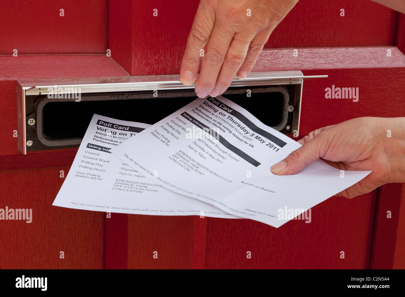 Polling cards being pushed through a front door letter box for the Av Referendum on May 5th 2011 England UK Stock Photo