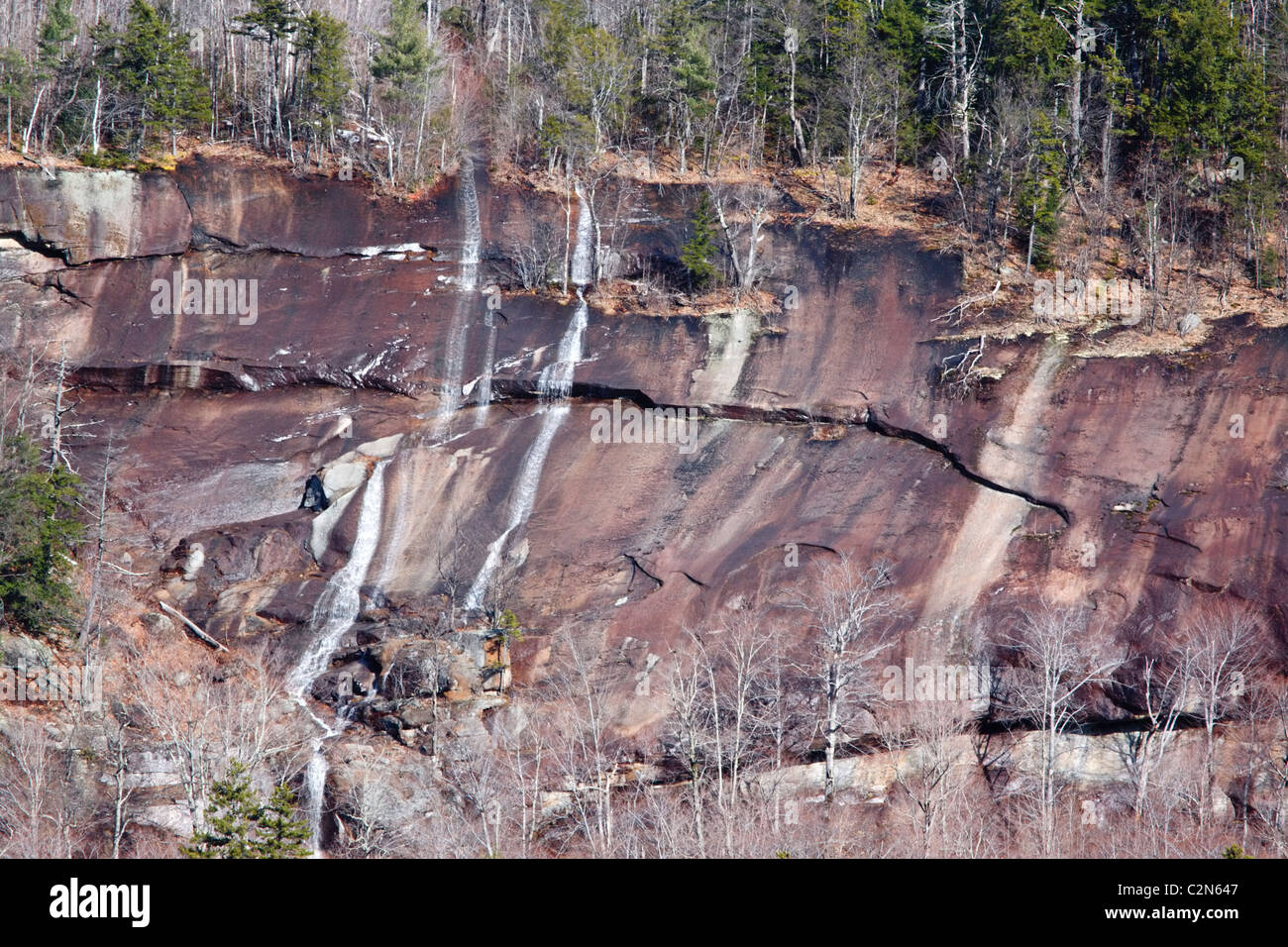 Spring snow melt and heavy rains drain down a cliff along the
