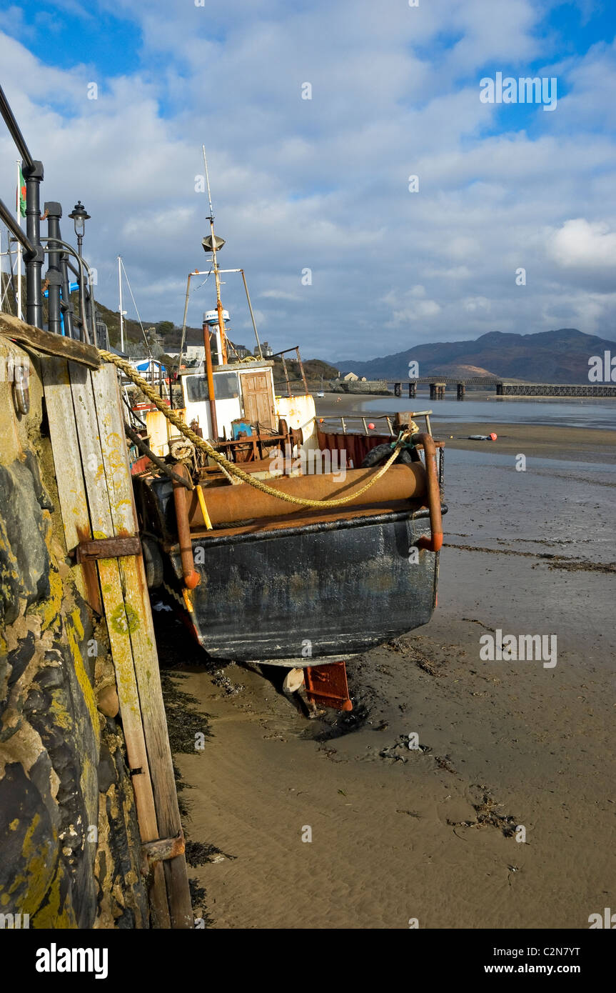 Fishing boat at low tide in winter Barmouth Harbour Gwynedd mid Wales UK United Kingdom GB Great Britain Stock Photo