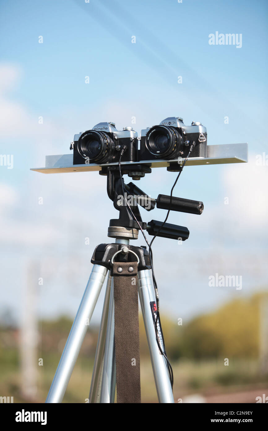 Two Minolta film cameras mounted on a bracket and tripod in the open air Stock Photo