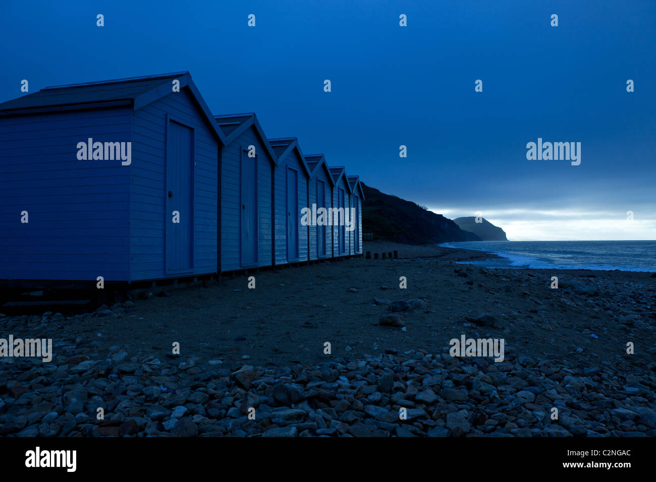 Beach Huts at dawn on Dorset coast at Charmouth Stock Photo