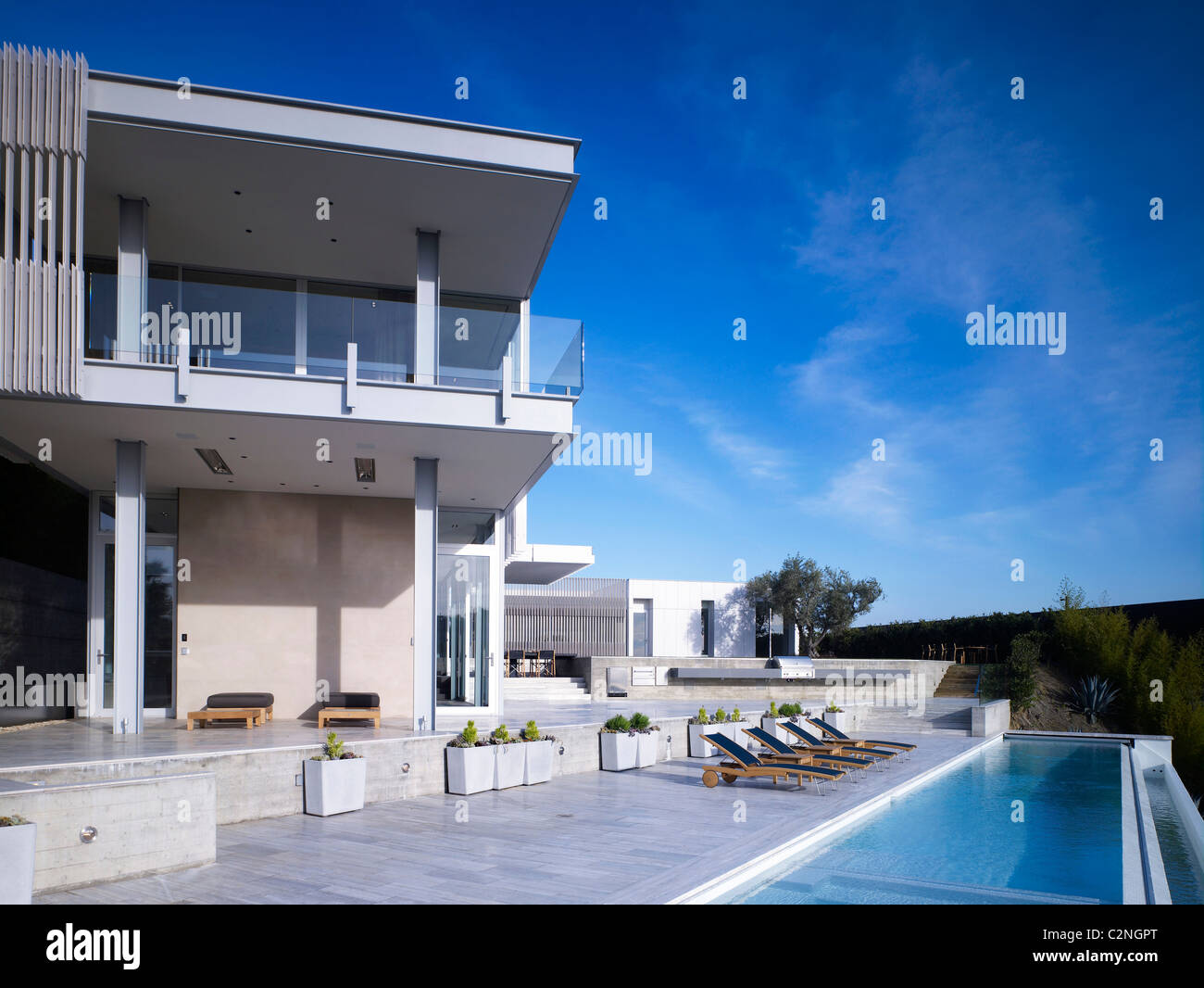 Modern detached house, West Hollywood, California. Rear general view with infinity pool and sun loungers Stock Photo