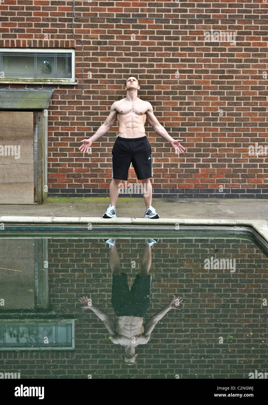 Strong professional athlete exercising by swimming pool for