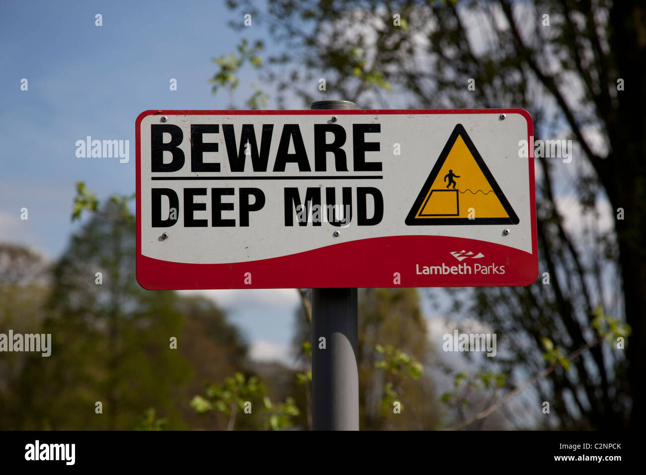 Beware deep mud sign near pond in Brockwell Park Stock Photo