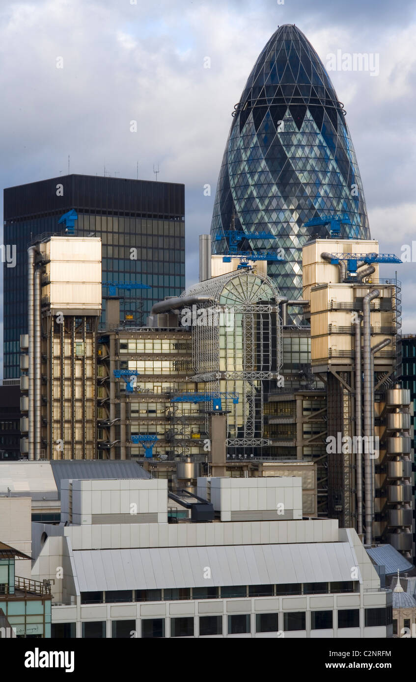 Swiss Re Headquarters, 30 St Mary Axe, (The Gherkin) London. with Lloyds Building. Stock Photo