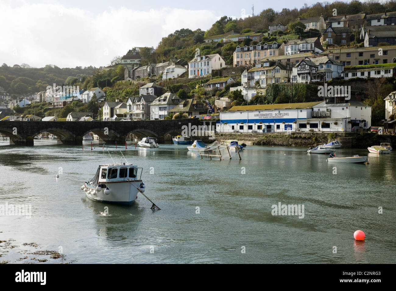 Harbour, bridge and moored boat overlooked by hillside homes / houses