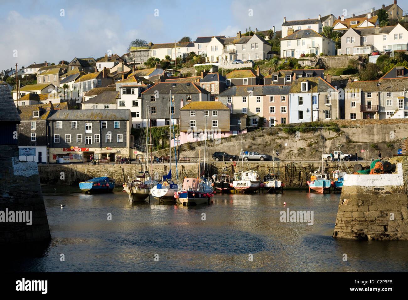 Harbour entrance and hillside homes / houses / residential property overlooking Mevagissey harbor in Cornwall. UK. Stock Photo