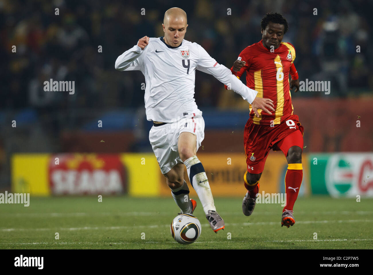 Michael Bradley of the United States (l) controls the ball against Anthony Annan of Ghana (r) during a 2010 World Cup match. Stock Photo