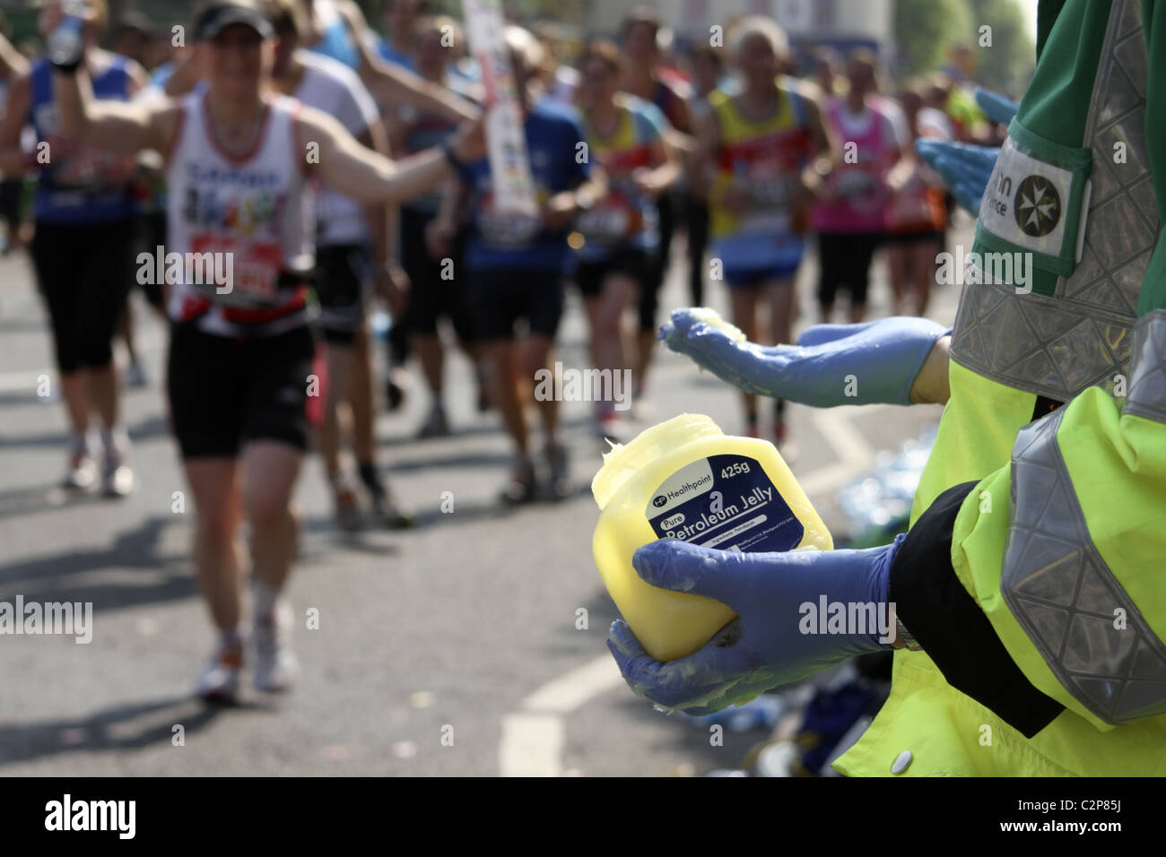 St. John's Ambulance volunteer offers petroleum jelly to runners on route of London Marathon Stock Photo