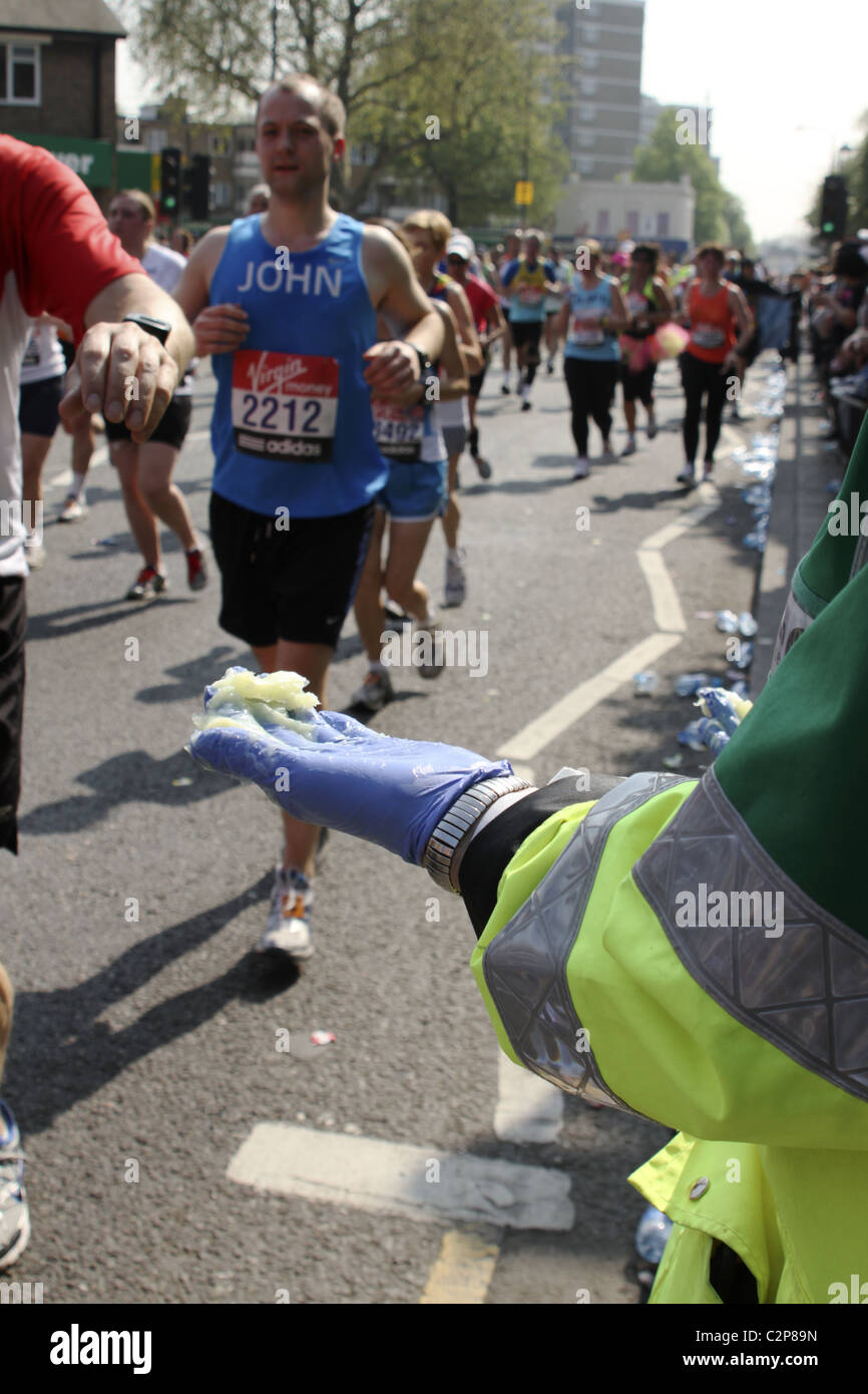 'St John's Ambulance' volunteer offers petroleum jelly to runners on route of London Marathon Stock Photo