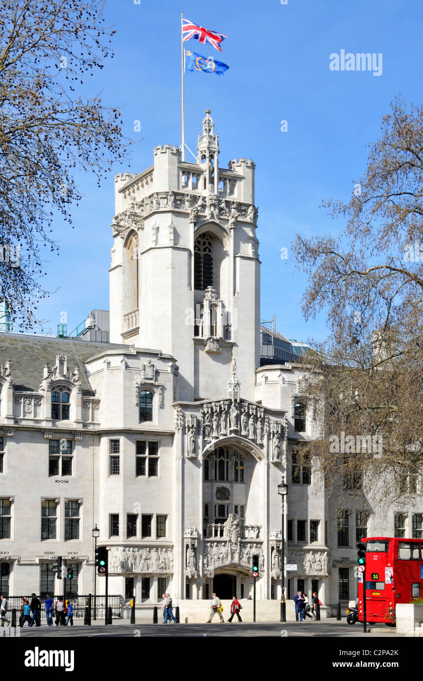 Union Jack & Emblem UKSC flags flying above stone tower old Middlesex Guildhall building now UK Supreme Court in Parliament Square London England UK Stock Photo