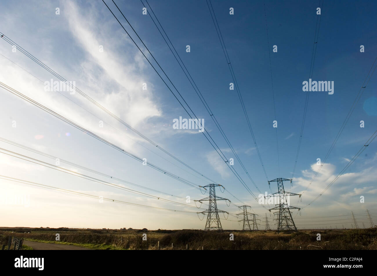 electricity pylons against blue sky Stock Photo - Alamy
