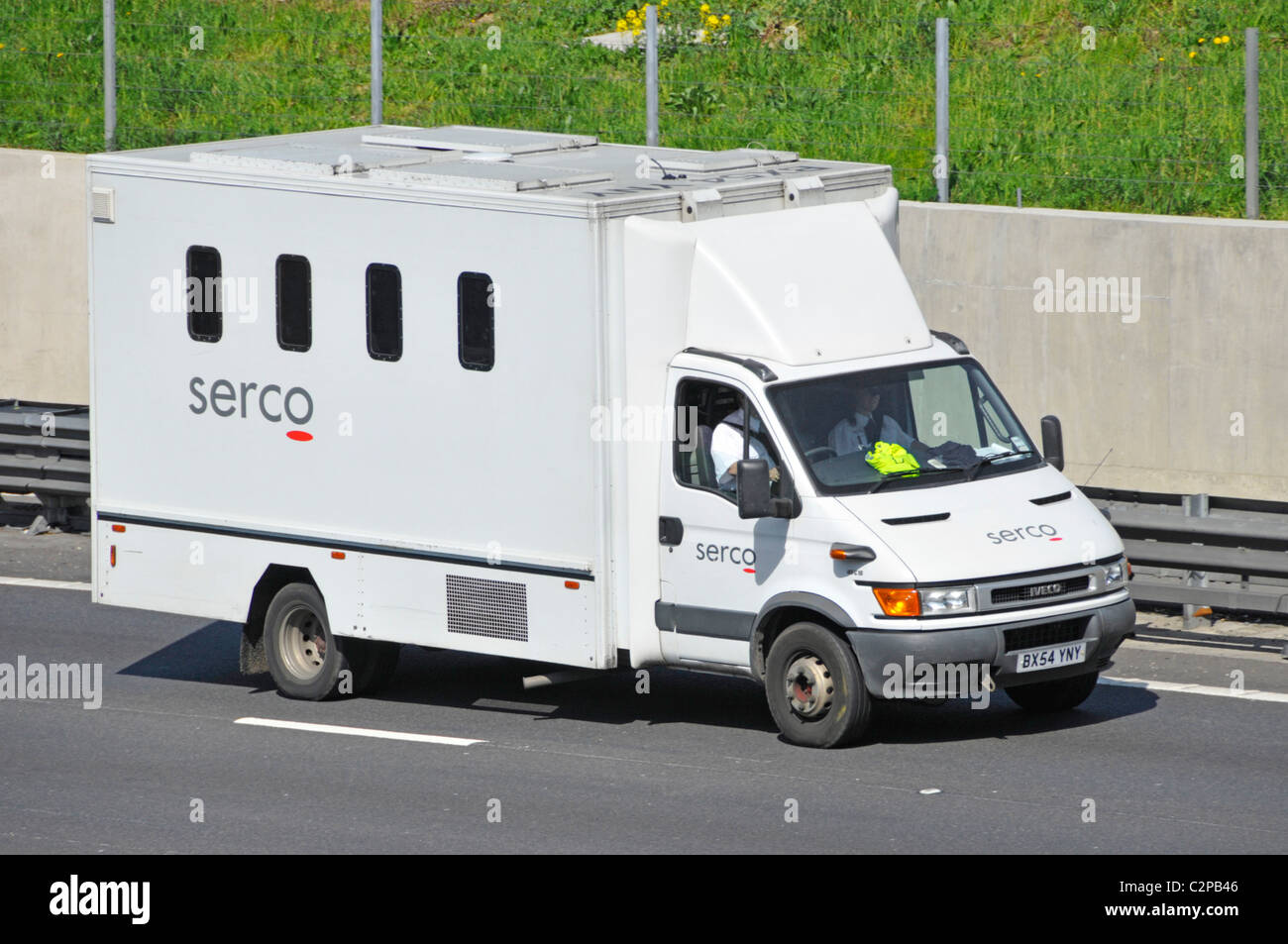 Secure prison to court prisoner transportation vehicle and driver operated by Serco van transport driving along M25 motorway Essex England UK Stock Photo