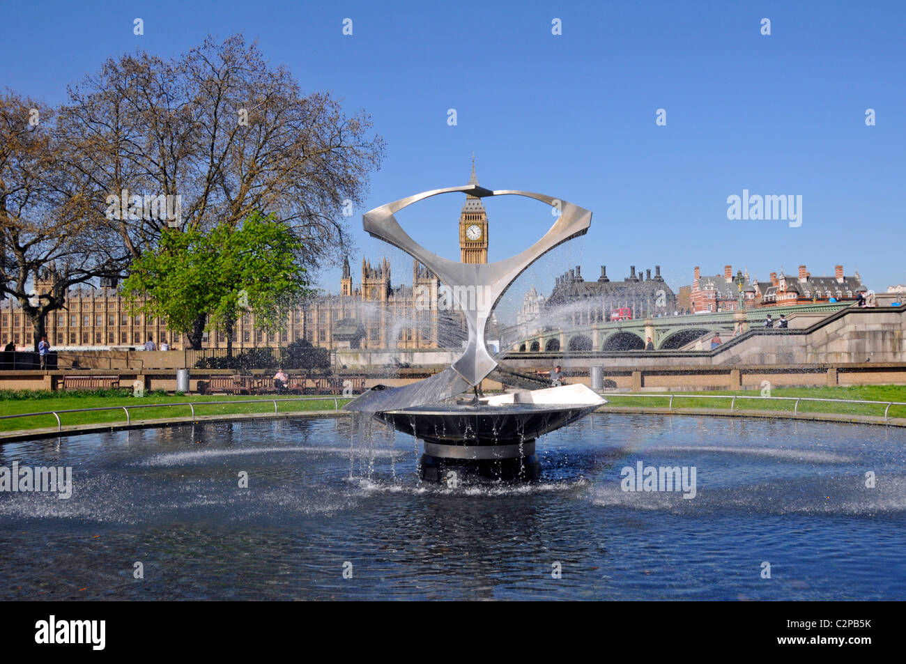 Steel water spray feature fountain & art sculpture by Naum Gabo beside Westminster Bridge Portcullis House & Big Ben & Houses of Parliament London UK Stock Photo