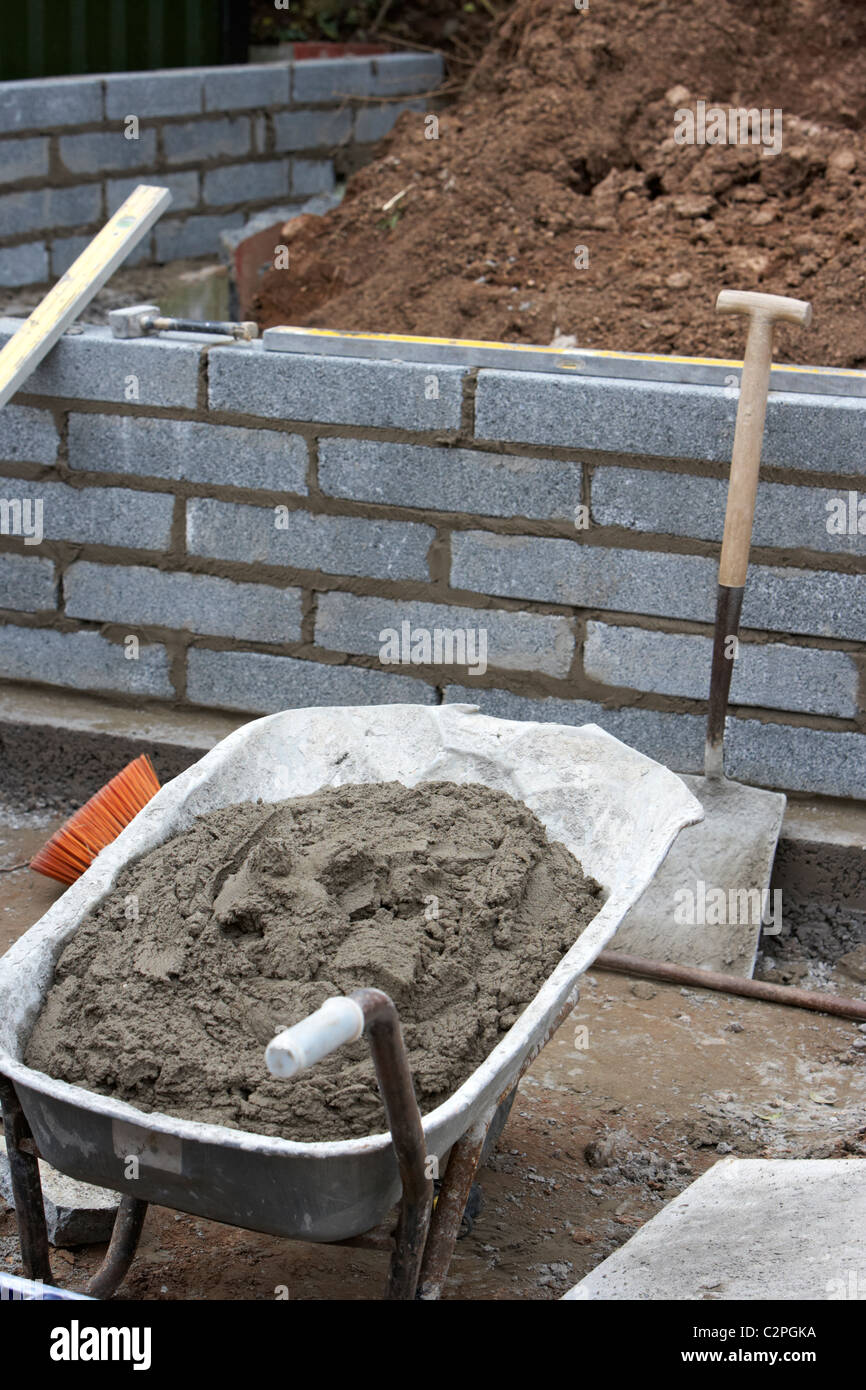 wheelbarrow filled with bricklaying mortar for building a block