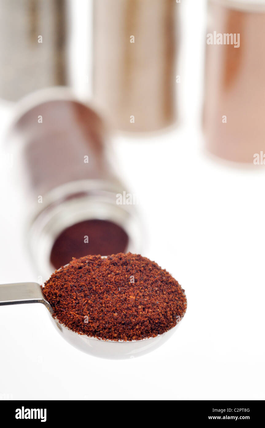 Measuring spoon filled with the spice chili pepper with other herb