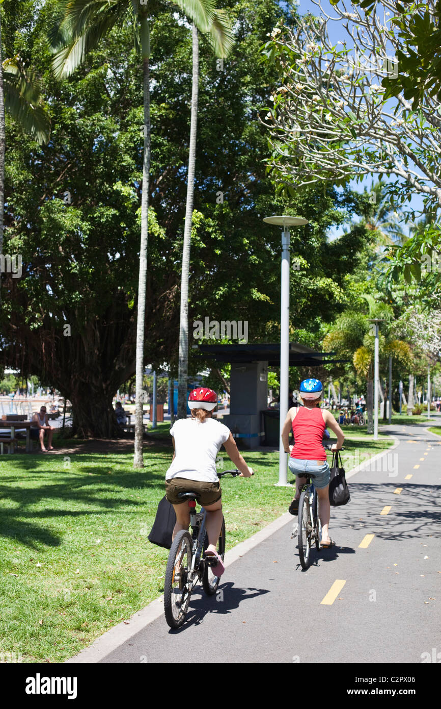 Tourists cycling along the Cairns Esplanade. Cairns, Queensland, Australia Stock Photo