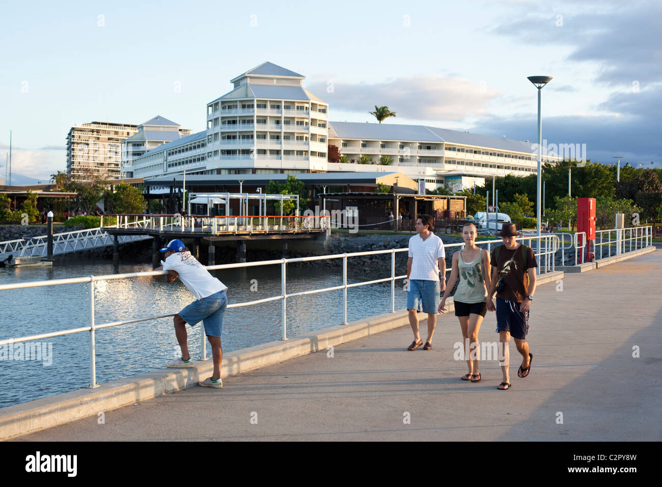 Tourists walking along Marlin Marina jetty with Shangri-La Hotel in background. Cairns, Queensland, Australia Stock Photo