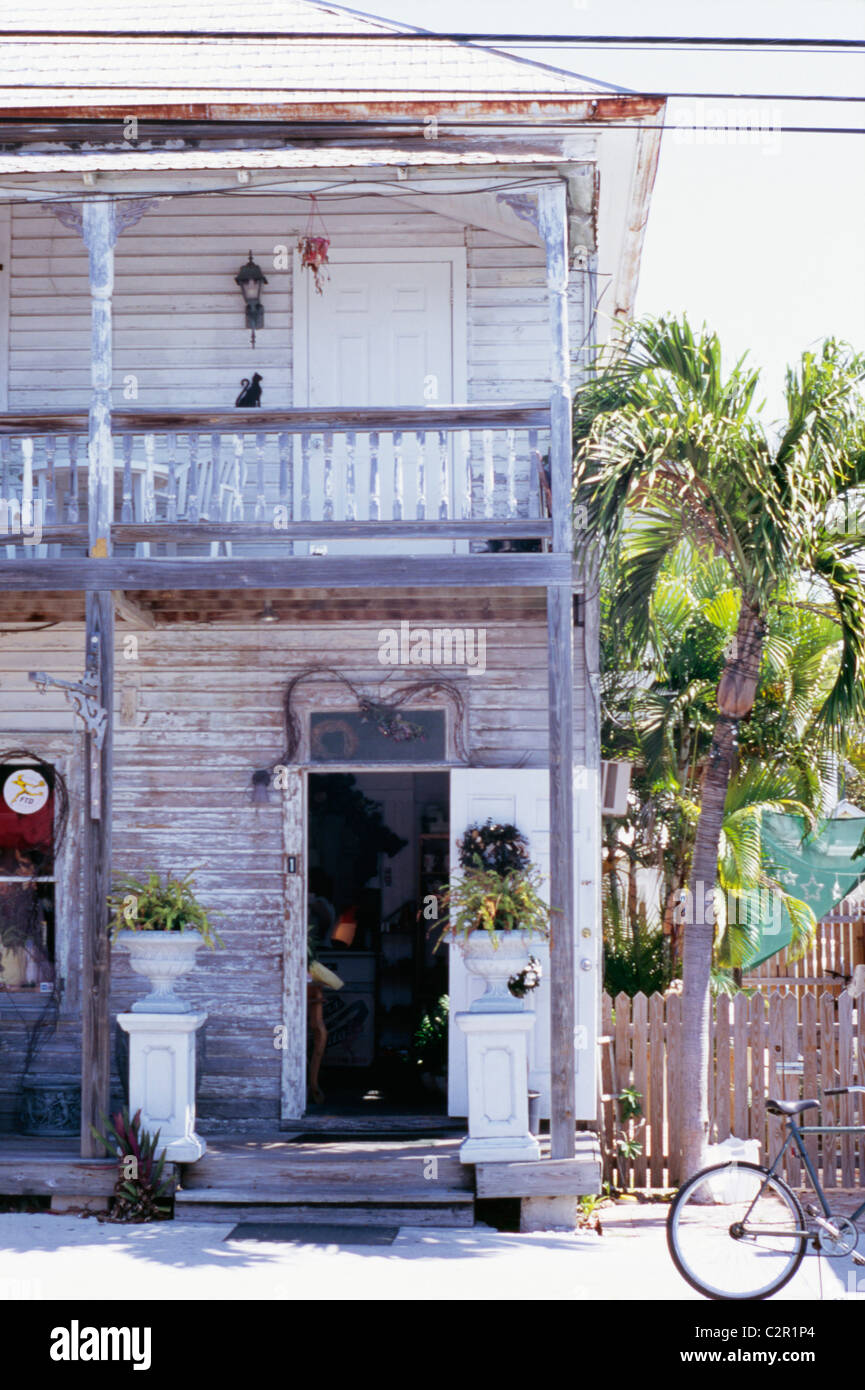 Two storey clapboard house, painted white, with balcony and verandah, weather beaten, peeling paint, urns containing ferns Stock Photo