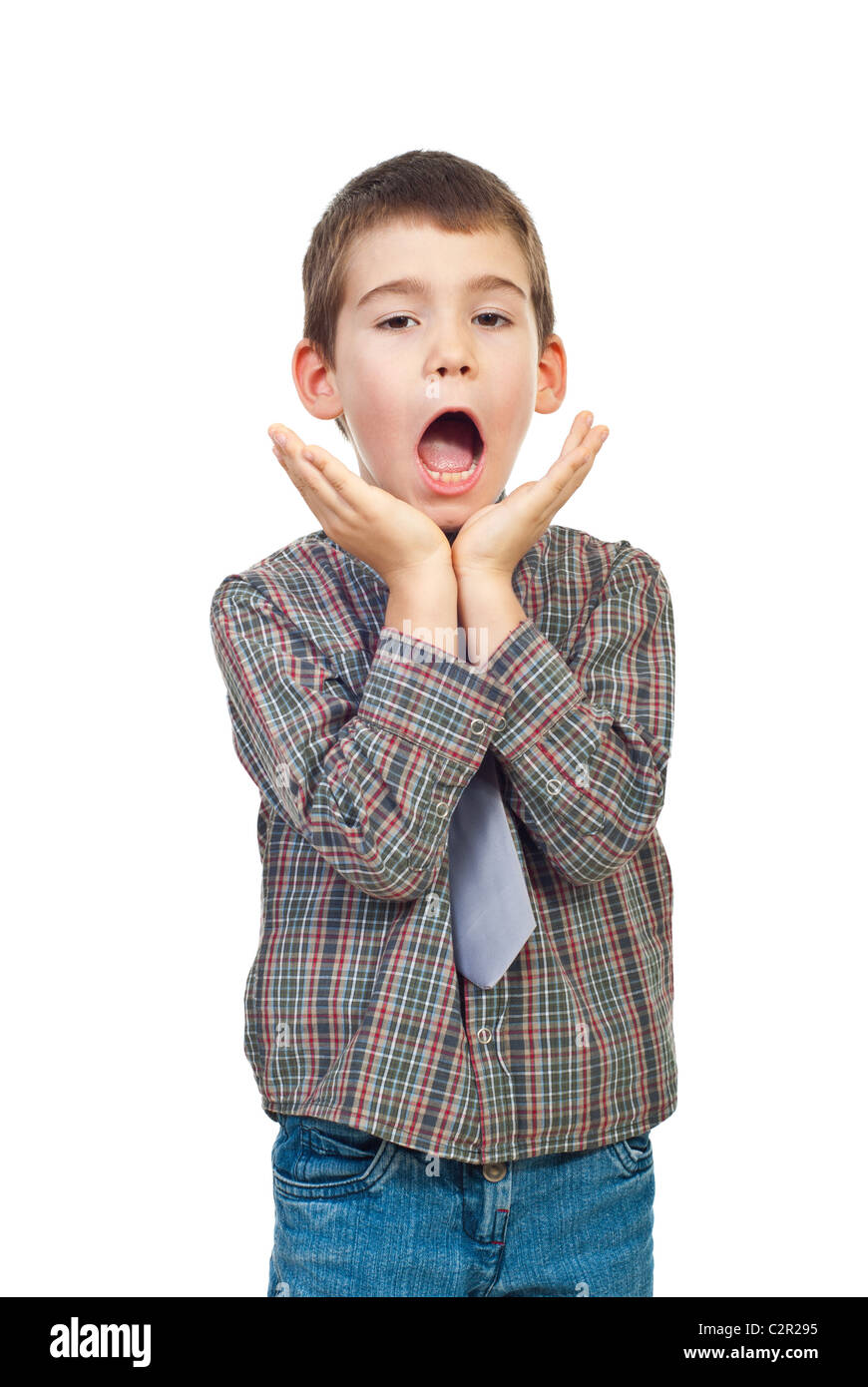 Scared and surprised six years old boy holding hands up to face and shouting isolated on white background Stock Photo