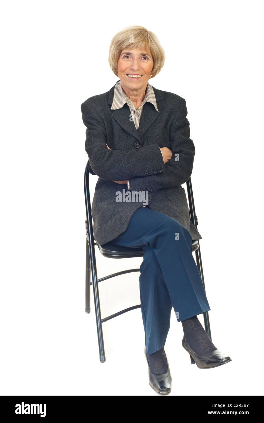 Happy senior business woman sitting on chair isolated on white ...
