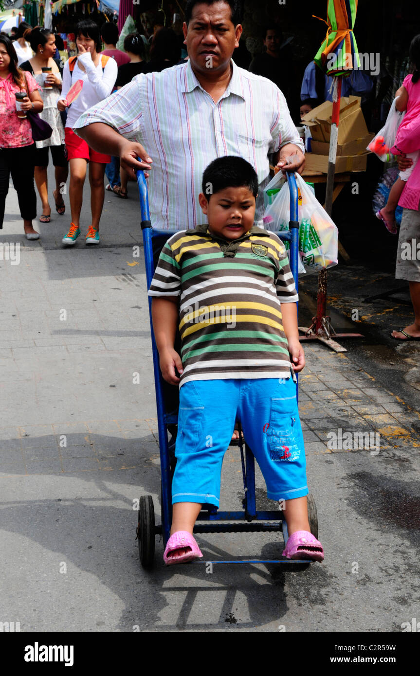 man pushing trolley with boy on it, chatuchak weekend market , bangkok ...