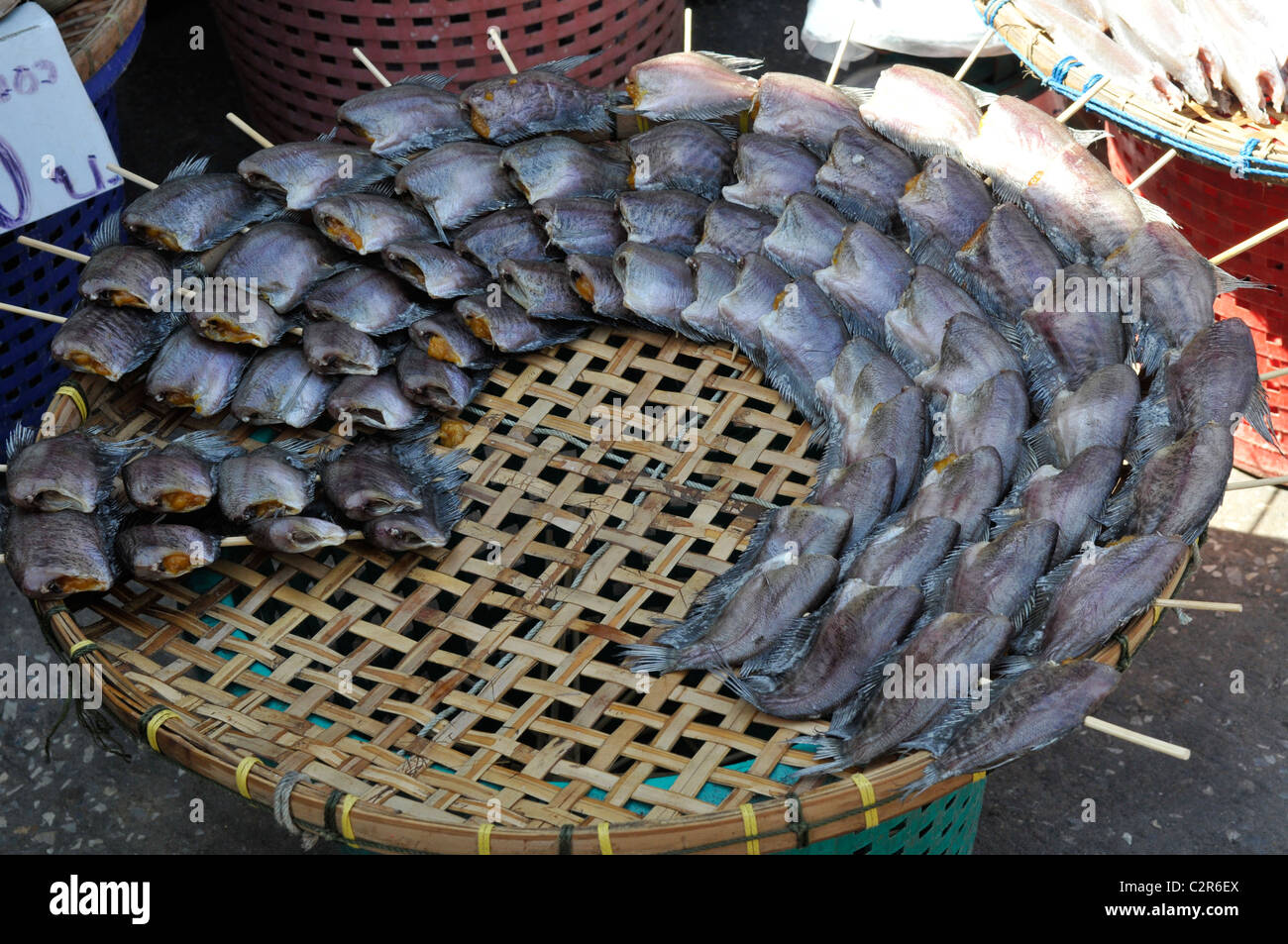dried snakeskin gourami fish on wicker basket, klong toei market