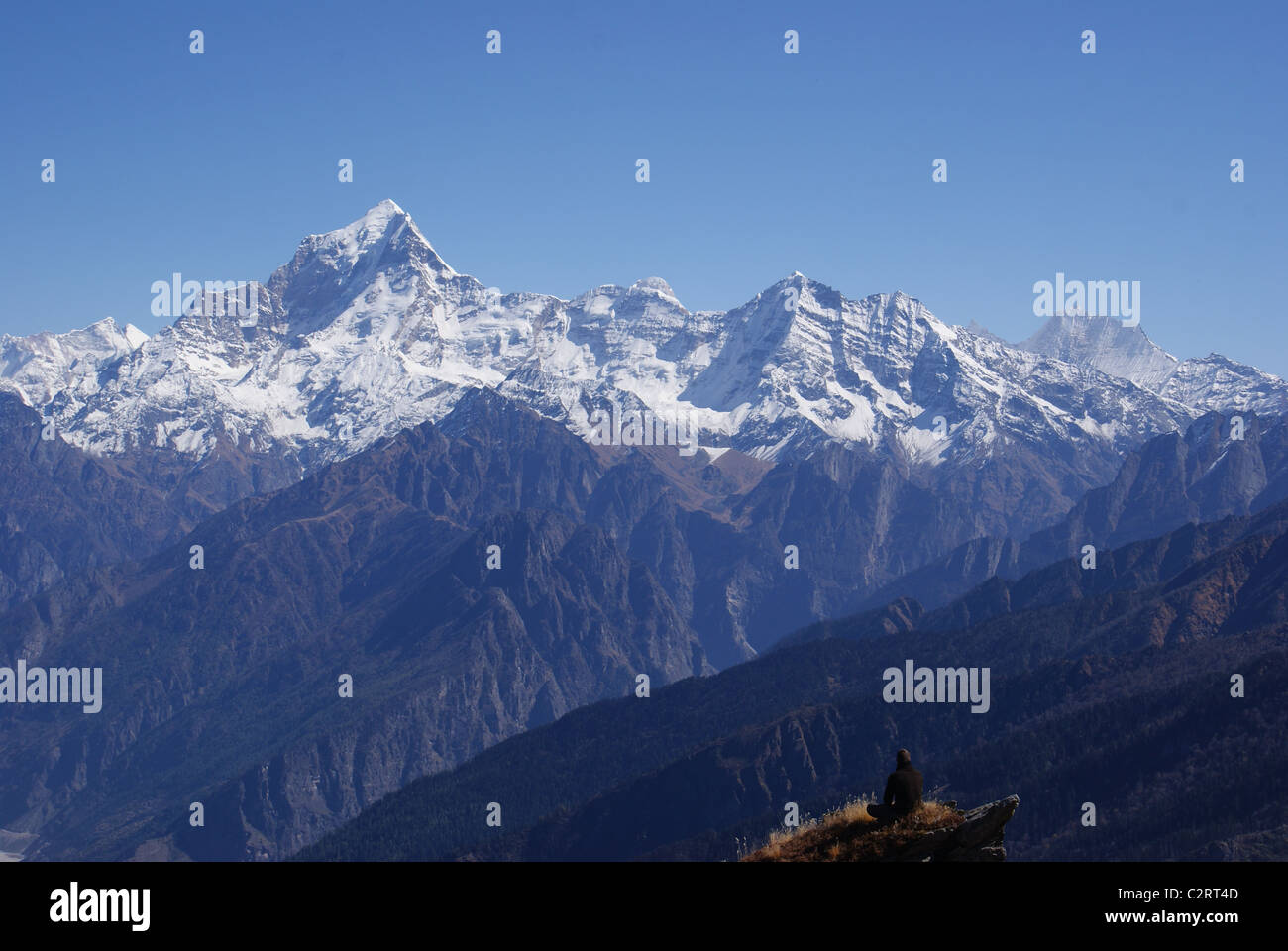 Garhwal Himalayas, India: A trekker takes in views of Dunagiri and Nanda Kot from beneath the Kuari Pass. Stock Photo