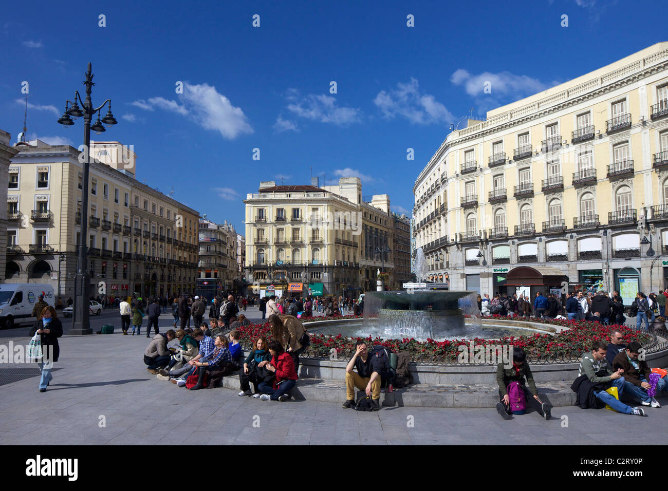 Visitors and tourists enjoy spring sunshine by the fountains in Puerta del Sol, Madrid, Spain, Europe, EU Stock Photo