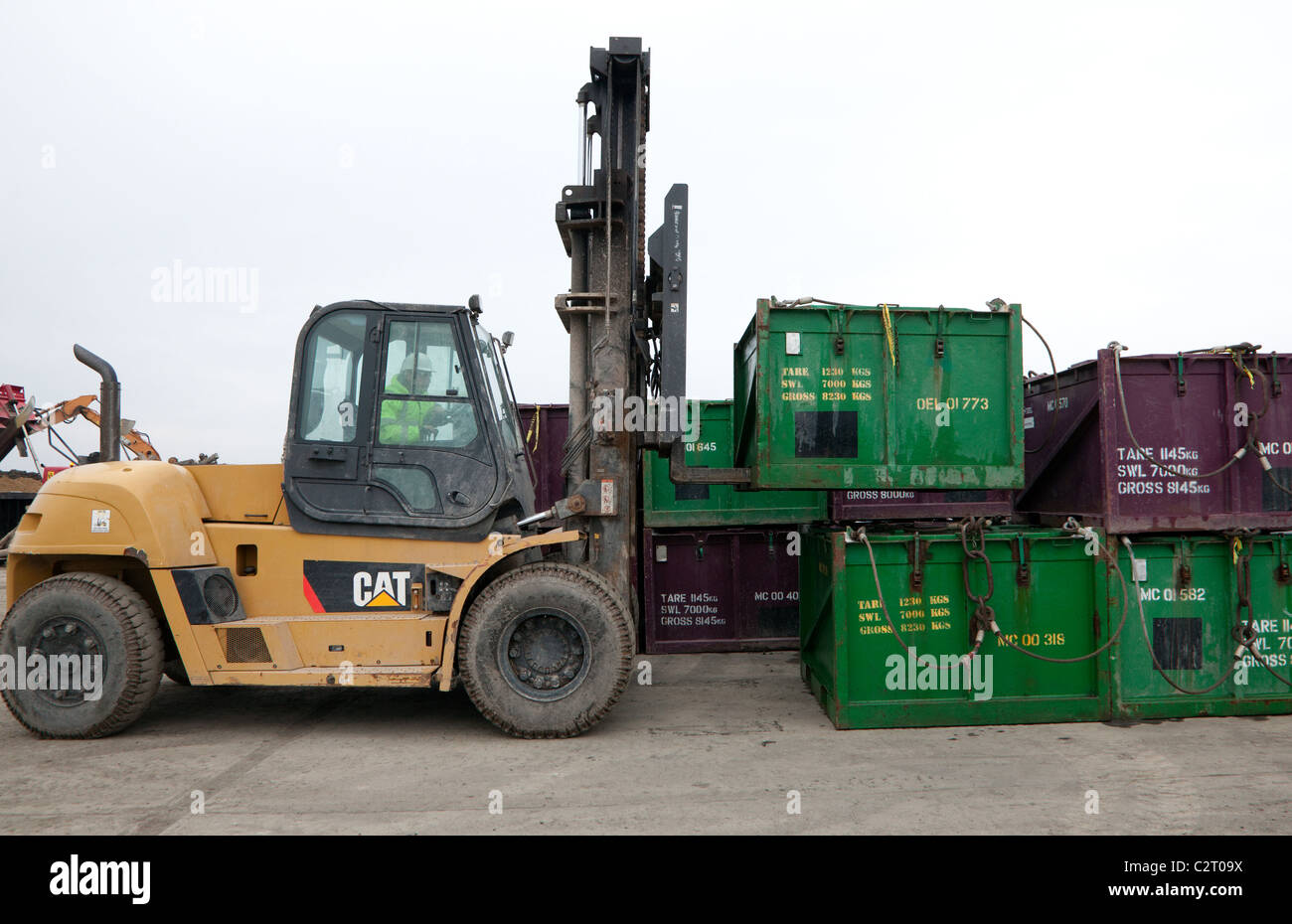 Industrial waste treatment plant, England - fork lift truck stacks empty waste containers at landfill site Stock Photo