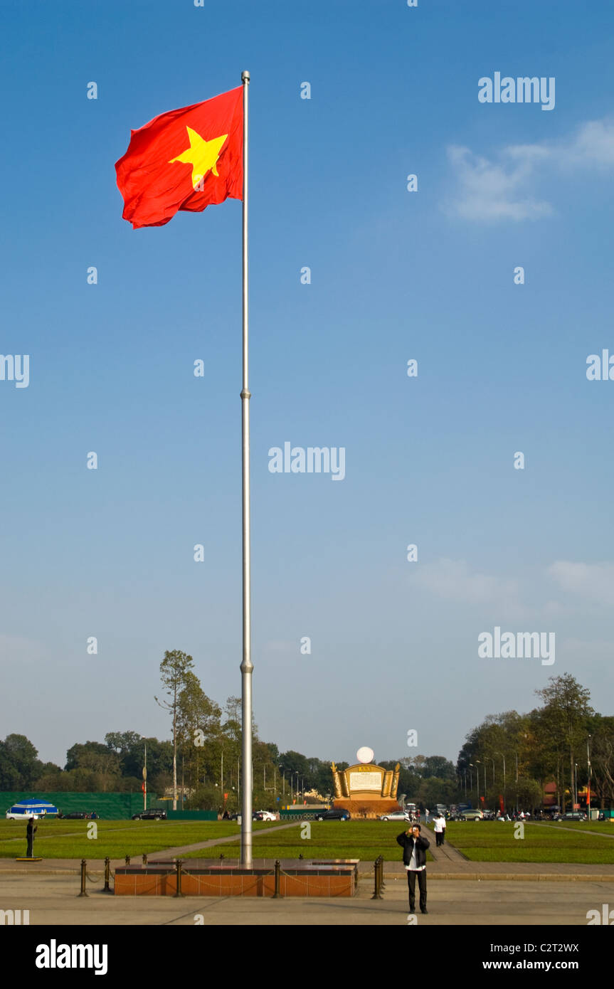 Vertical view of the 'cờ đỏ sao vàng' (red flag with a yellow star) the National flag of Vietnam in Ba Dinh Square in the sun. Stock Photo