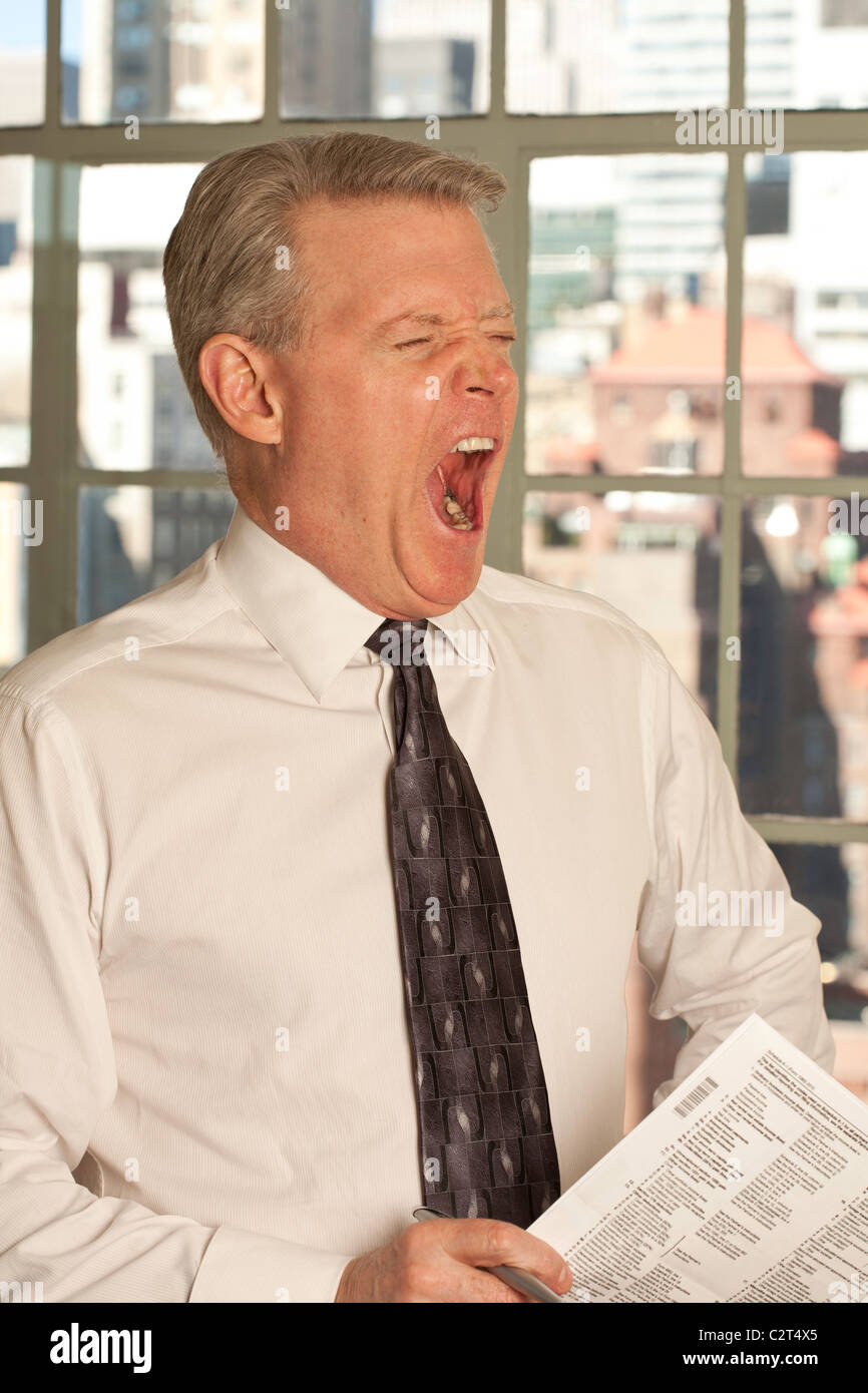 Yawning Mature Businessman at the Office Stock Photo