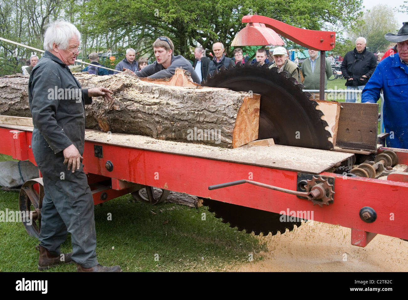Men demonstrating the Cutting of wood with Tractor driven Rack Saw   Old Working Farm Machinery Stock Photo