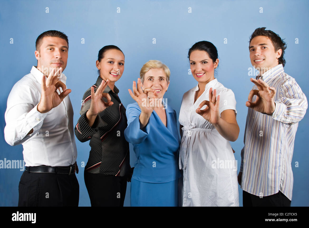Group of united teamwork standing in a line and showing okay sign and ...
