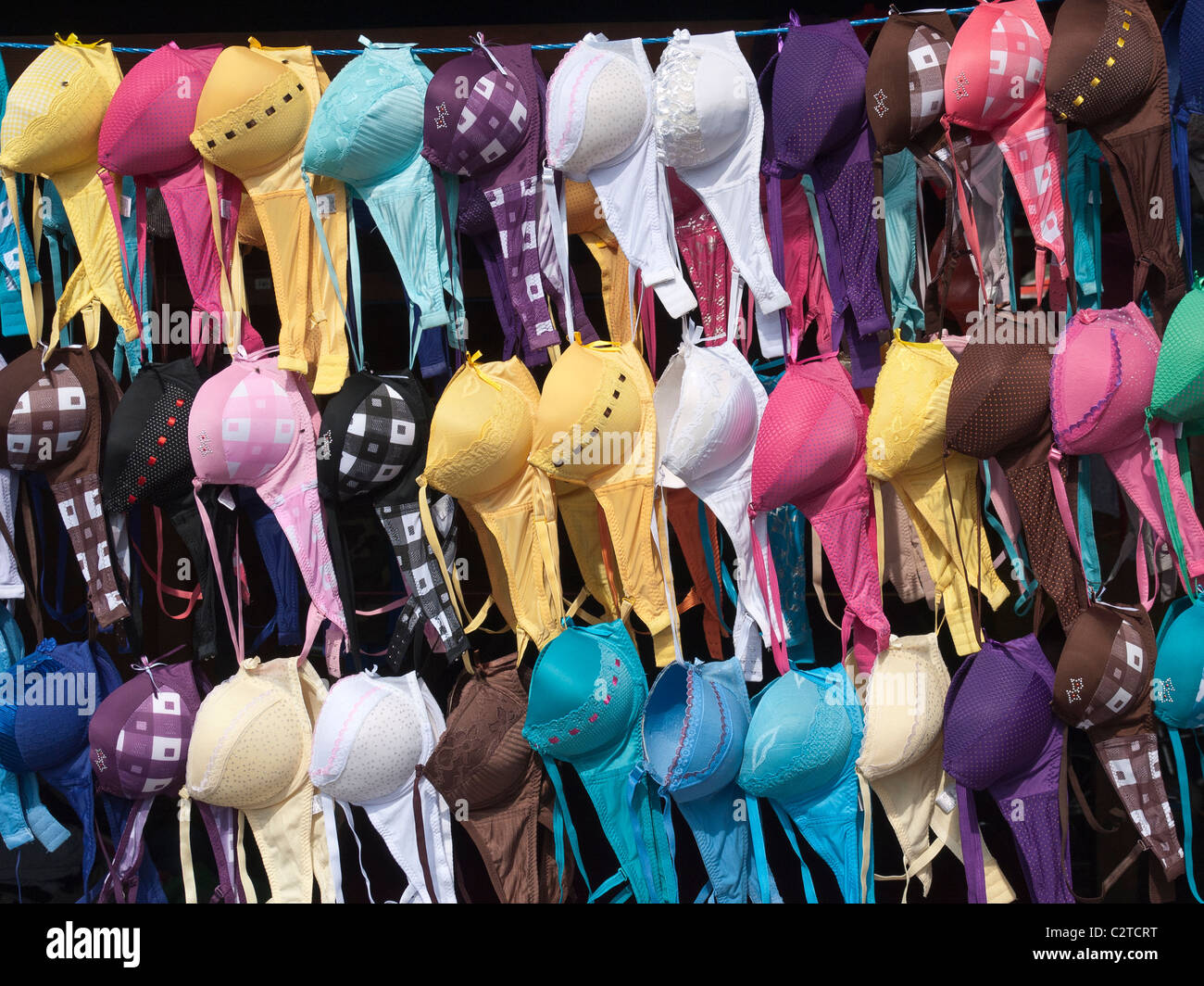 A public market vendor's stall displays the repeated forms of colorful bras  in the Spanish colonial city of Antigua, Guatemala Stock Photo - Alamy