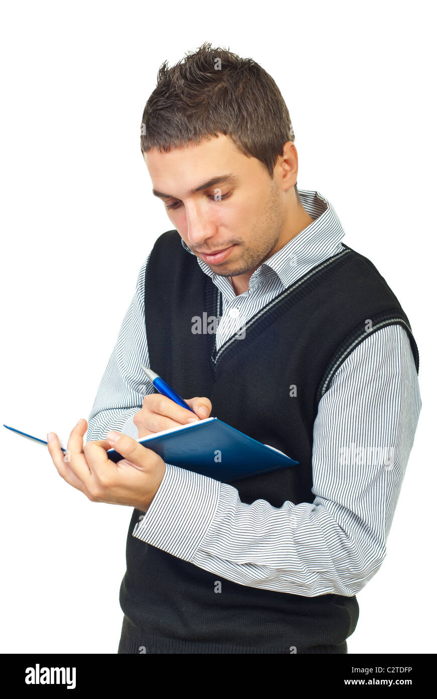 Young male executive taking notes in his personal agenda isolated on