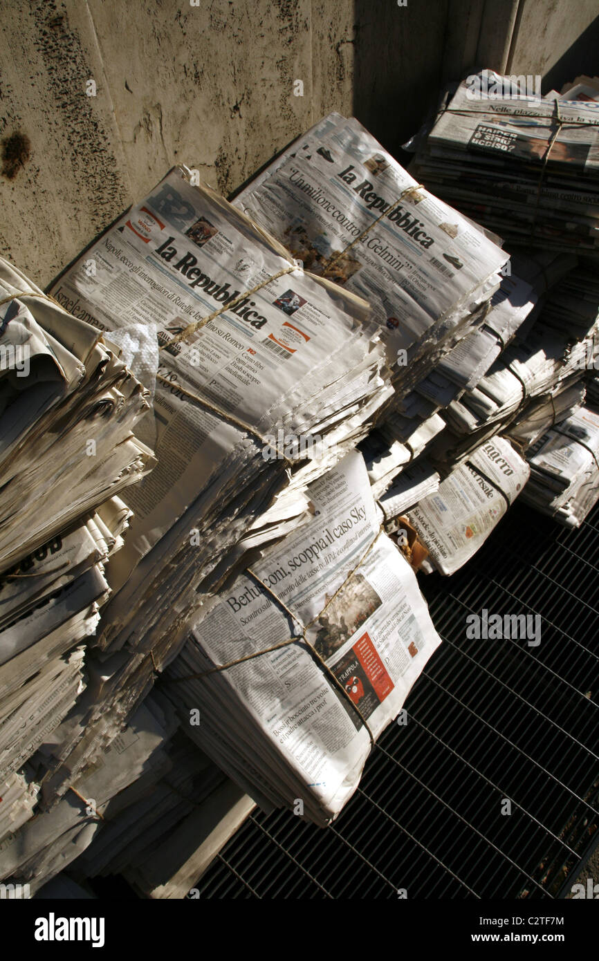 pile of old used newspapers left in street road in city town Stock Photo