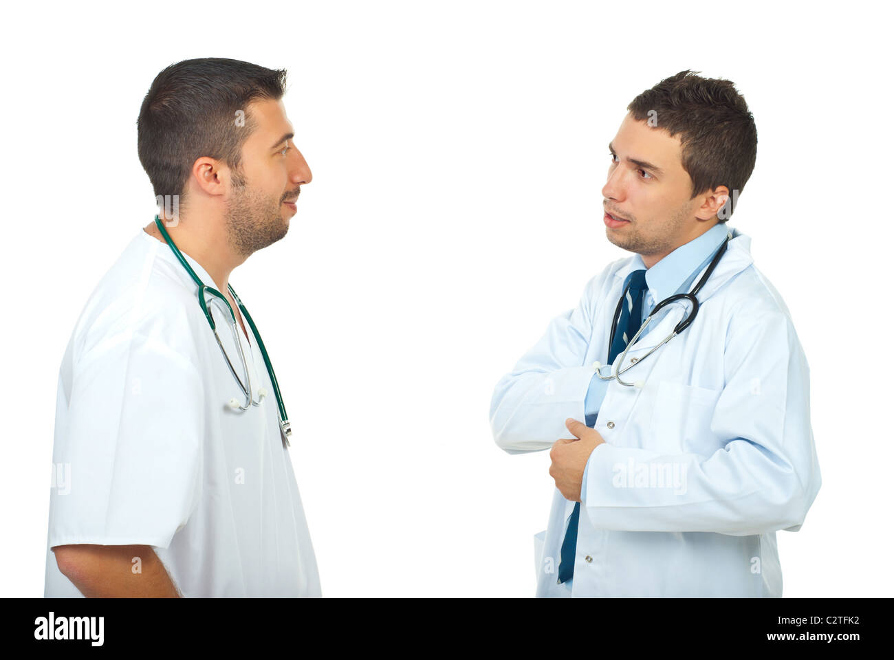 Two doctors men having conversation and one of them search something in his overall pocket isolated on white background Stock Photo