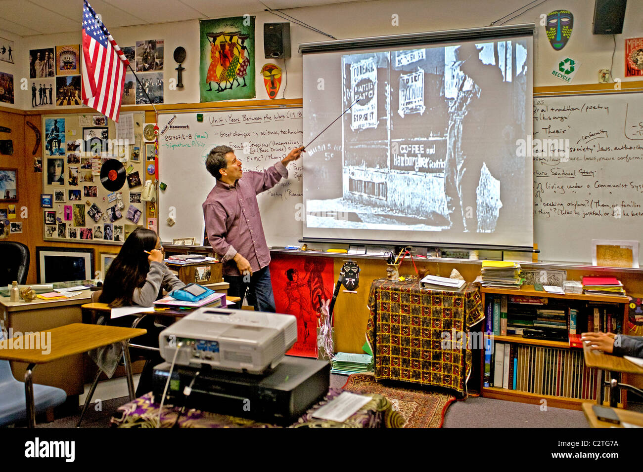 A history teacher uses a liquid crystal display (LCD) projector while lecturing to his class on