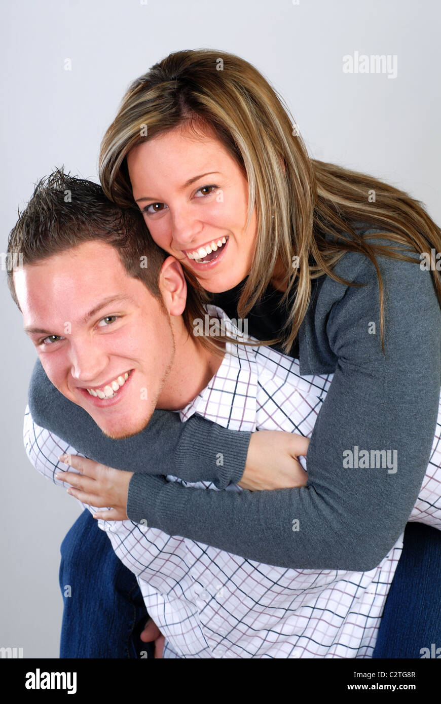 Attractive Young Couple Playing Around Giving A Piggy Back Ride Stock Photo