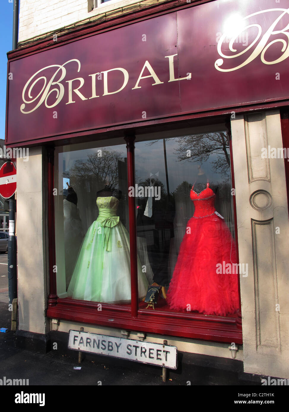 Brightly coloured PINK wedding dress in shop window. Stock Photo