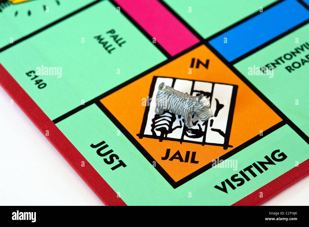 A dog piece in jail on a monopoly game board UK Stock Photo